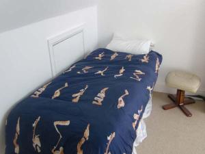 a bed with a blue comforter with horses on it at The Beach House Apartment in Buncrana