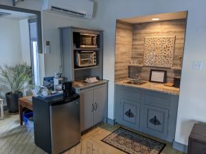 a kitchen with a sink and a counter with a refrigerator at Gingerbread House Inn - We Are Open - Winter, Spring, Summer and Fall in Wolfville