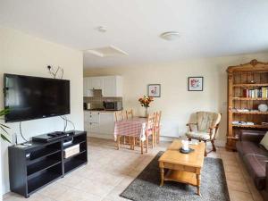 a living room with a couch and a tv and a table at 5 Kilnamanagh Manor in Dundrum
