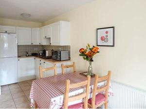 a kitchen with a table with a vase of flowers on it at 5 Kilnamanagh Manor in Dundrum