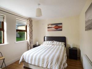 a white bedroom with a bed and a window at 5 Kilnamanagh Manor in Dundrum