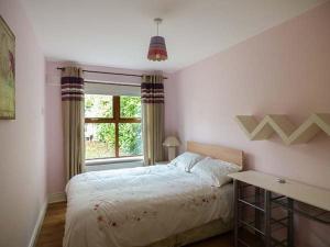 a bedroom with a large bed and a window at 5 Kilnamanagh Manor in Dundrum