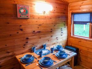 a wooden room with a table with blue dishes on it at Cabin 2 in Glen