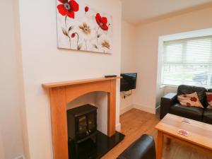 a living room with a fireplace and a couch at 63 Moinin in Kilkee