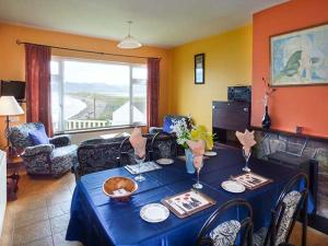 Rossbeigh Beach Cottage No 6 في Rossbeigh: غرفة معيشة مع طاولة مع قطعة قماش من الطاولة الزرقاء