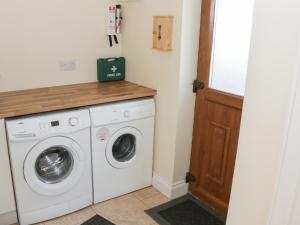 een wasruimte met een wasmachine en droger bij Cloonkee Cottage in Crossmolina