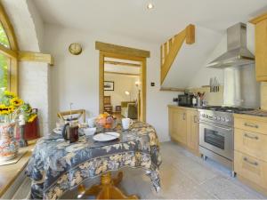 a kitchen with a table in the middle of it at Pittards Farm Cottage in Lambrook