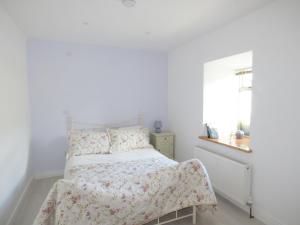 a white bedroom with a bed and a window at 80 New Street in Lismore