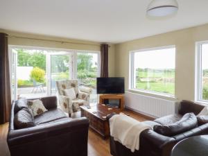 a living room with two couches and a television at Sanderling Lodge in Greenfield Cross Roads