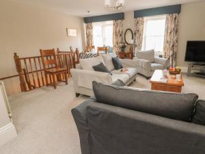a living room with couches and a tv at Jackson Cottage in Alnwick
