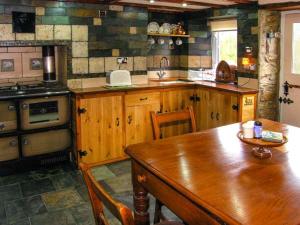 MydrimにあるJohnny's Cottageのキッチン(木製テーブル、コンロ付)