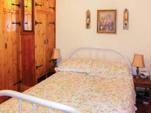 MydrimにあるJohnny's Cottageのベッドルーム1室(ベッド1台、ランプ付きテーブル2台付)