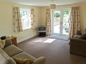 a living room with a couch and a tv at Summer Farm Cottage in Bedale