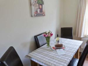 a table with a cake and a bottle of wine at Summer Farm Cottage in Bedale