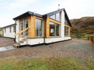 a house with large windows on a gravel yard at Torgorm in Glenelg