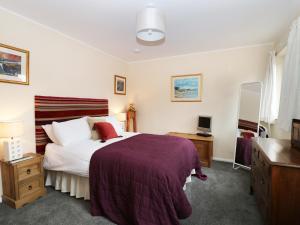 a bedroom with a bed and a desk and a television at Torgorm in Glenelg