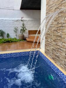 a swimming pool with a water fountain at Hotel Lider in Santa Cruz de la Sierra