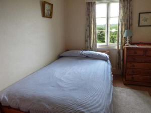 um quarto com uma cama, uma cómoda e uma janela em Fiddlers Green em Bucknell