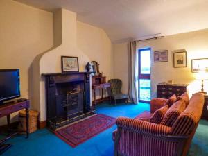 a living room with two couches and a fireplace at The Mallard Studio in Dyrham