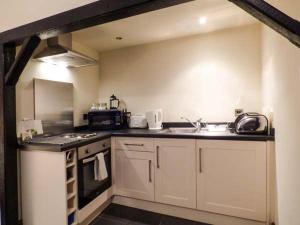 a kitchen with a sink and a stove top oven at The Mallard Studio in Dyrham
