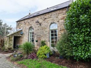 un edificio de ladrillo con ventanas y plantas en el patio en The Old Chapel, en Chesterfield