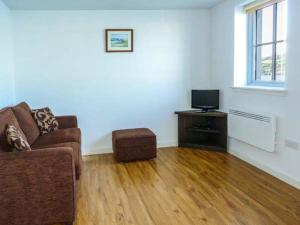 a living room with a couch and a television at The Clamshell in Isle of Whithorn
