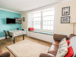 a living room with a couch and a window at Apartment 2 in Tenby