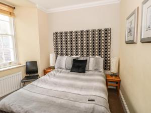 a bedroom with a large bed with a black headboard at Apartment 2 in Tenby
