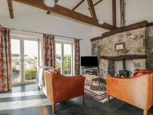 a living room with two chairs and a fireplace at Buttermere in Cockermouth