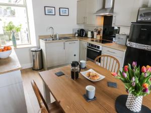a kitchen with a table with a plate of food on it at East Crossthwaite Cottage in Newbiggin