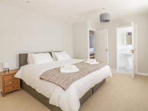 a bedroom with a large bed with two towels on it at Ivy Cottage in Colchester