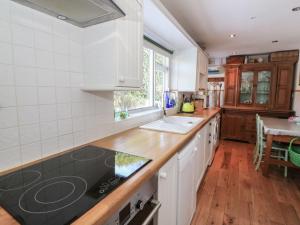 Ystrad MeurigにあるDolau Meurigの白いキャビネットとカウンタートップを備えたキッチン