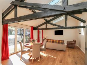 a living room with a table and a couch at Zeal Cottage in Zeal Monachorum