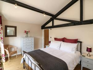 a bedroom with a large bed with red pillows at Zeal Cottage in Zeal Monachorum
