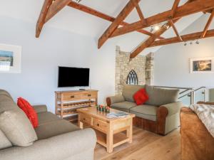 a living room with two couches and a tv at Helford in Penryn