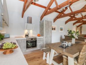 a kitchen with a wooden table and a dining room at Helford in Penryn