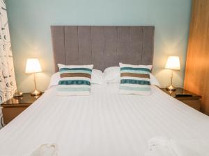 スカーバラにあるScarborough Apartments - One Bedのベッドルーム(白い大型ベッド、ランプ2つ付)
