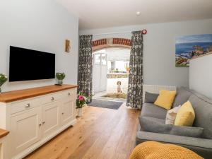 a living room with a couch and a flat screen tv at Dexter in Penryn