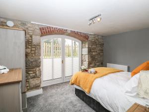 a bedroom with a large bed and a stone wall at Dexter in Penryn