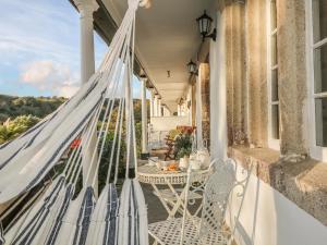 a hammock on the porch of a house at Sea Cliff Cottage in Pentewan