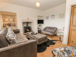 a living room with two couches and a fireplace at Sea Cliff Cottage in Pentewan