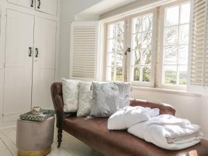 a couch with pillows on it in a room with windows at Sea Cliff Cottage in Pentewan +44 photos