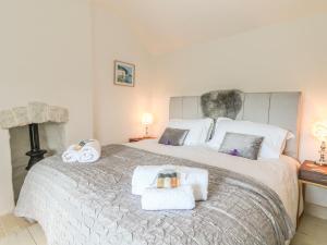 a bedroom with a large bed with towels on it at Sea Cliff Cottage in Pentewan