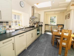 a kitchen with a sink and a table with a dining room at Mill Dam Farm Cottage in High Bentham