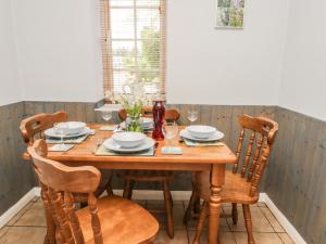 jadalnia z drewnianym stołem i krzesłami w obiekcie Smugglers Rock Cottage w mieście Ravenscar