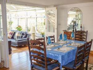 a dining room with a blue table and chairs at Castle Hill Farm in Hemyock