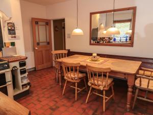 a kitchen with a wooden table and some chairs at Valley View Cottage in Foxt