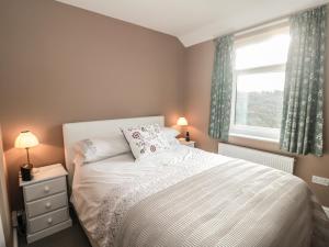 a bedroom with a white bed and a window at Valley View Cottage in Foxt