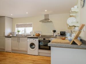 a kitchen with a washing machine and a sink at Woodpecker Lodge in High Ham