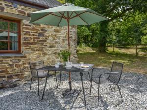 einen Tisch mit einem grünen Sonnenschirm und Stühlen in der Unterkunft Miners Dry in Gunnislake + 9 Fotos